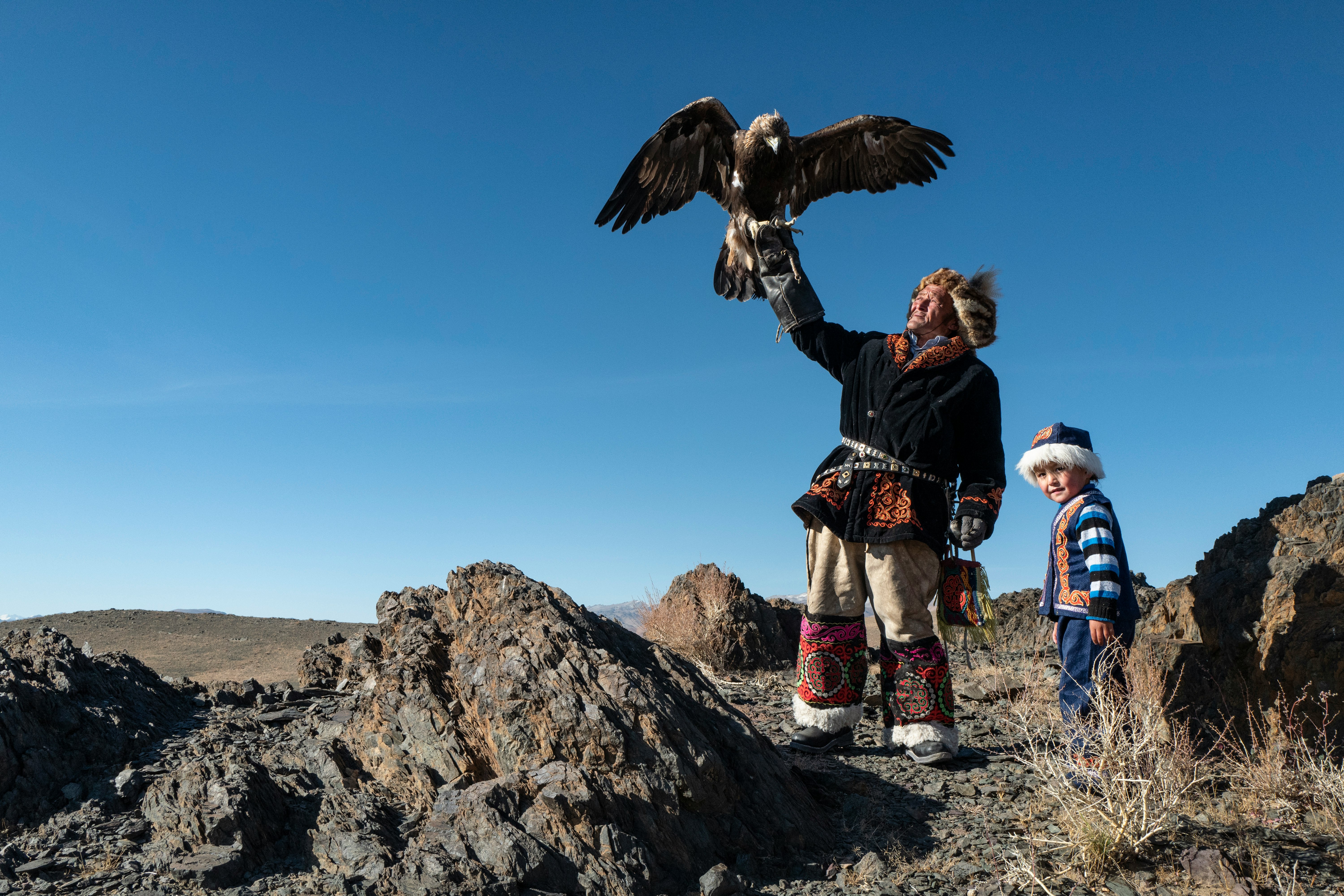 Native American man standing while holding eagle